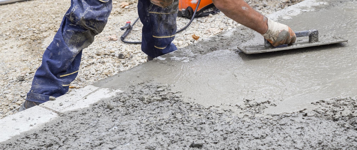 Close up view of a concrete worker smoothing a surface