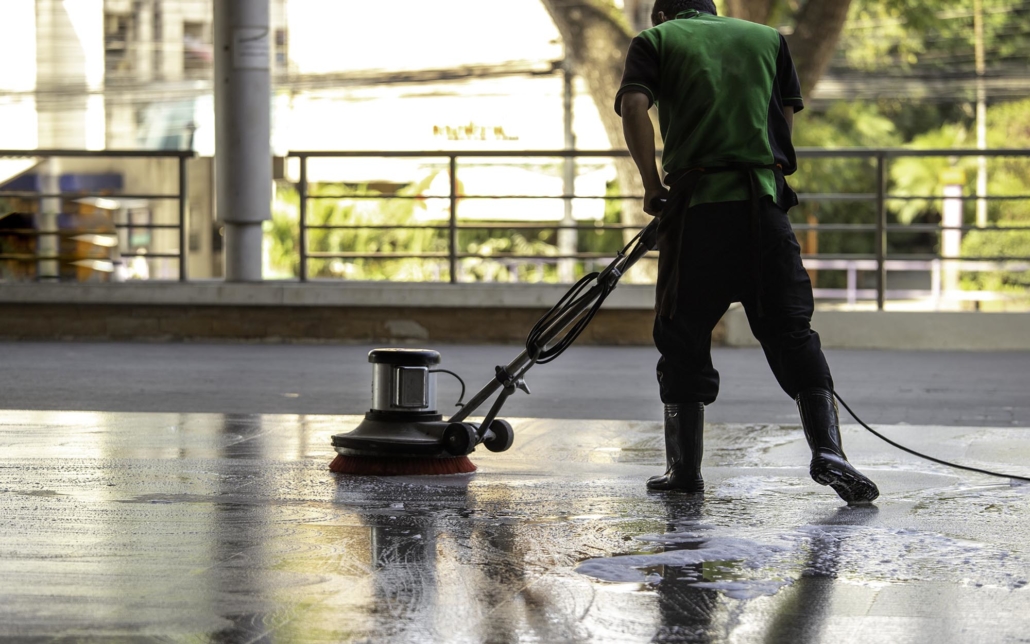 View of a worker using a concrete cleaning machine