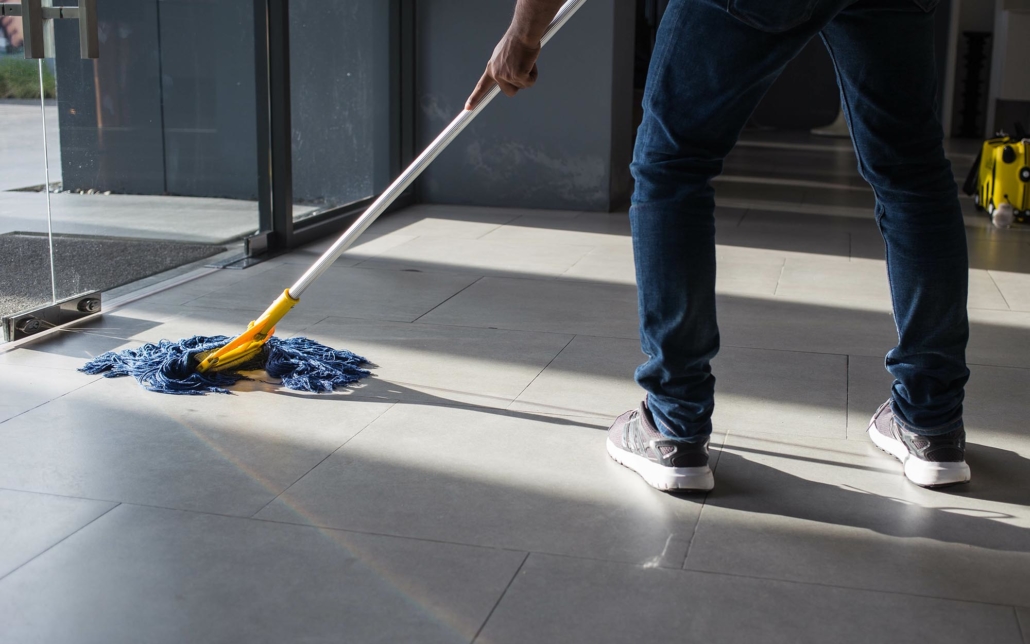 Side view of a worker mopping a floor