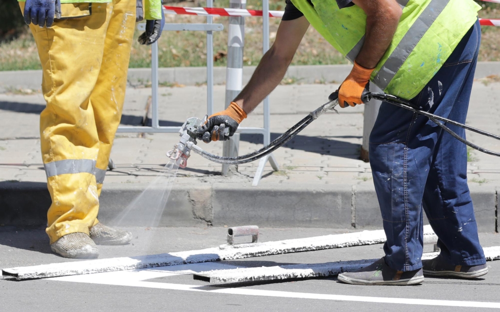 View of working spraying parking lot lines